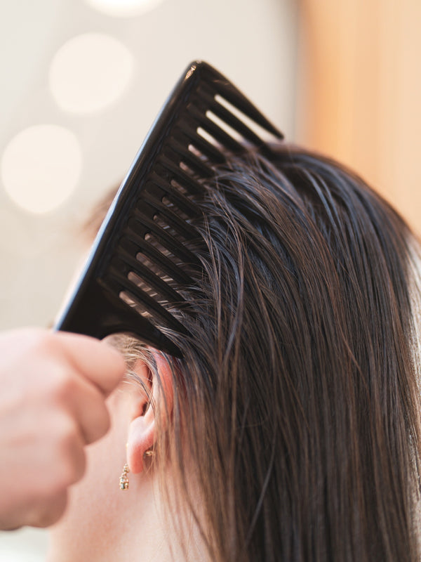 Combing hair with wide toothed comb